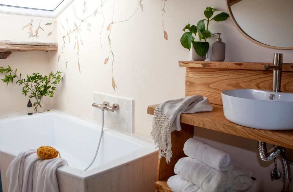 une salle de bain avec une baignoire et un lavabo dans l'établissement Wishome-Casa con piscina climatizada, cerca Comillas, à Valdaliga 