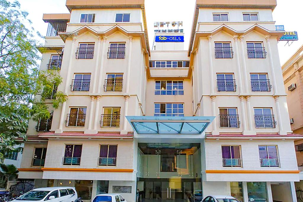 a large white building with cars parked in front of it at Hotel Summit in Ahmedabad