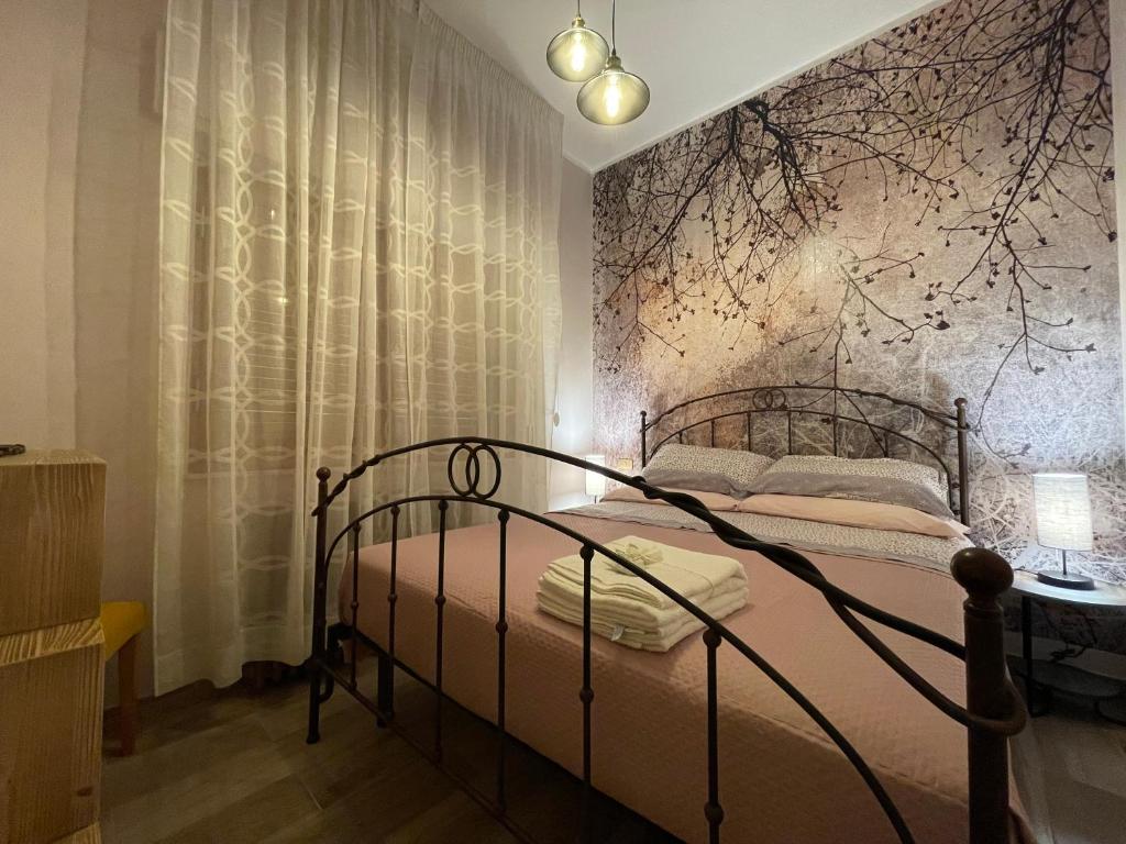 sypialnia z metalowym łóżkiem i ścianą w obiekcie Casa del castorino w mieście Abbadia San Salvatore