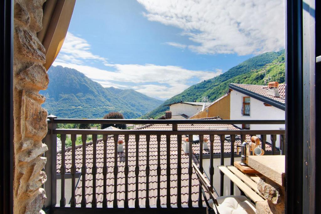 Eine Frau steht auf einem Balkon mit Bergblick in der Unterkunft Casa Pollicina in Margno