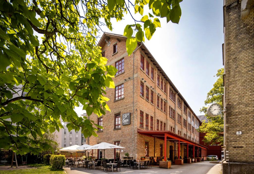 un ancien bâtiment en briques avec des tables et des chaises dans l'établissement JUFA Hotel Bregenz, à Bregenz