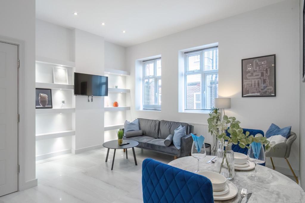 ein Wohnzimmer mit einem Sofa und einem Tisch in der Unterkunft LiveStay-Modern & Stylish Apartments in Didcot in Didcot