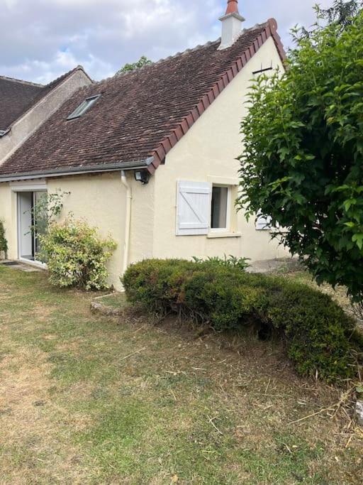 une maison blanche avec un arbre devant dans l'établissement La petite maisonnette, à Saint-Georges-sur-Cher