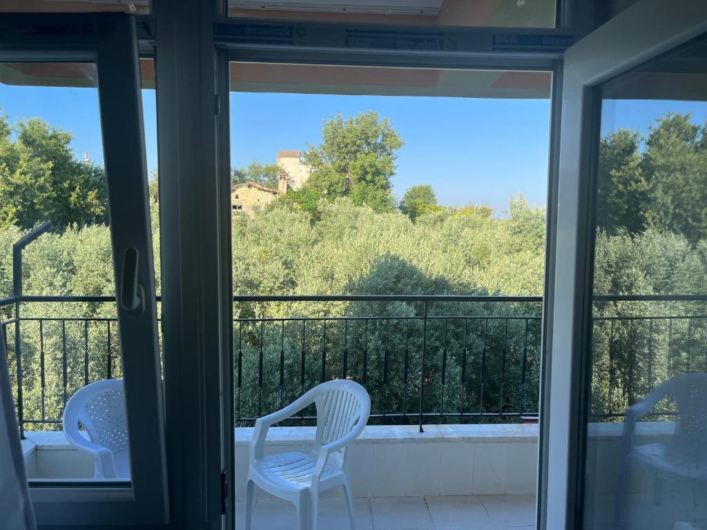 mit Blick auf einen Balkon mit zwei weißen Stühlen in der Unterkunft Inside olive trees, 7 min to sea in Serik