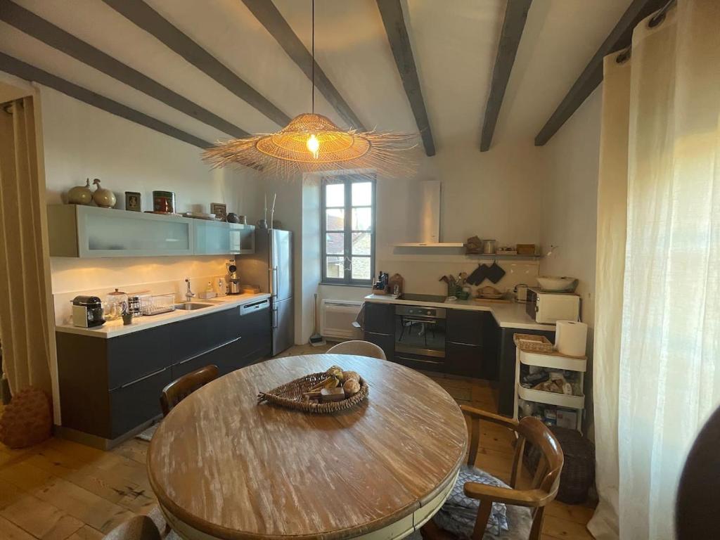 kuchnia z drewnianym stołem i jadalnią w obiekcie Ancien Presbytère de charme w mieście Thédirac