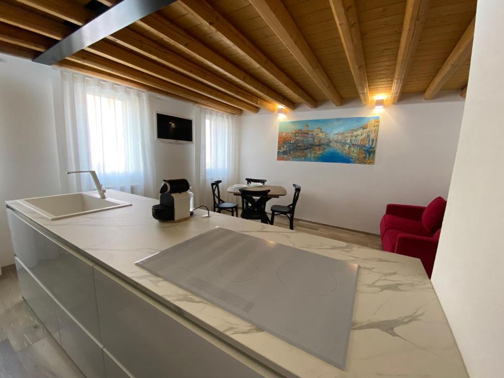 a kitchen and living room with a counter and a table at Elva Suite House in Chioggia