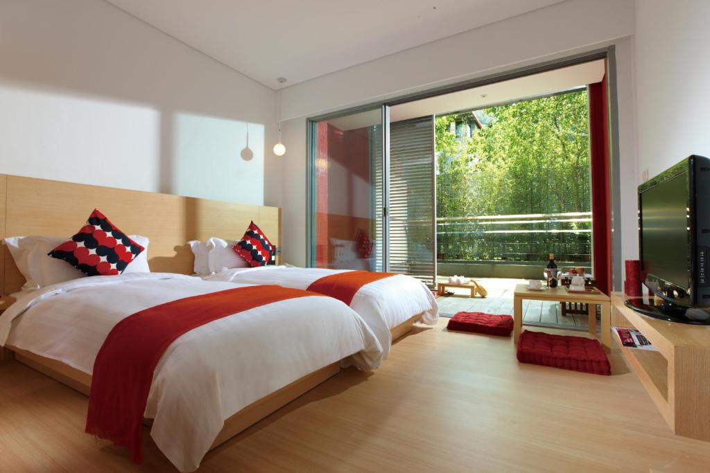 a bedroom with a large bed and a large window at Hotel Double One in Taipei