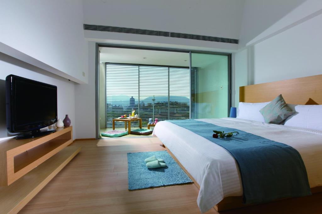 a bedroom with a large bed and a flat screen tv at Hotel Double One in Taipei