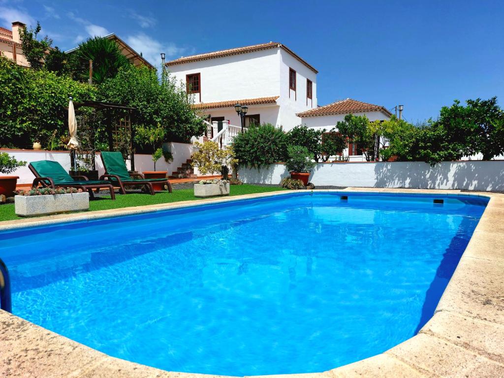 een blauw zwembad voor een huis bij La Roseta in Barlovento