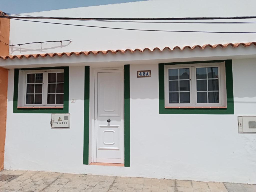 a white house with a door and two windows at Casa Palmés in Valles de Ortega