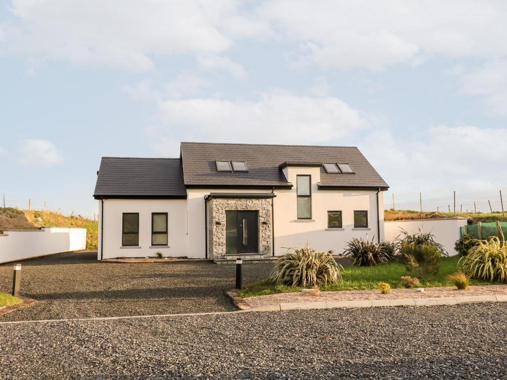 a white house with a black roof at The Beachhouse in Cashel Hill