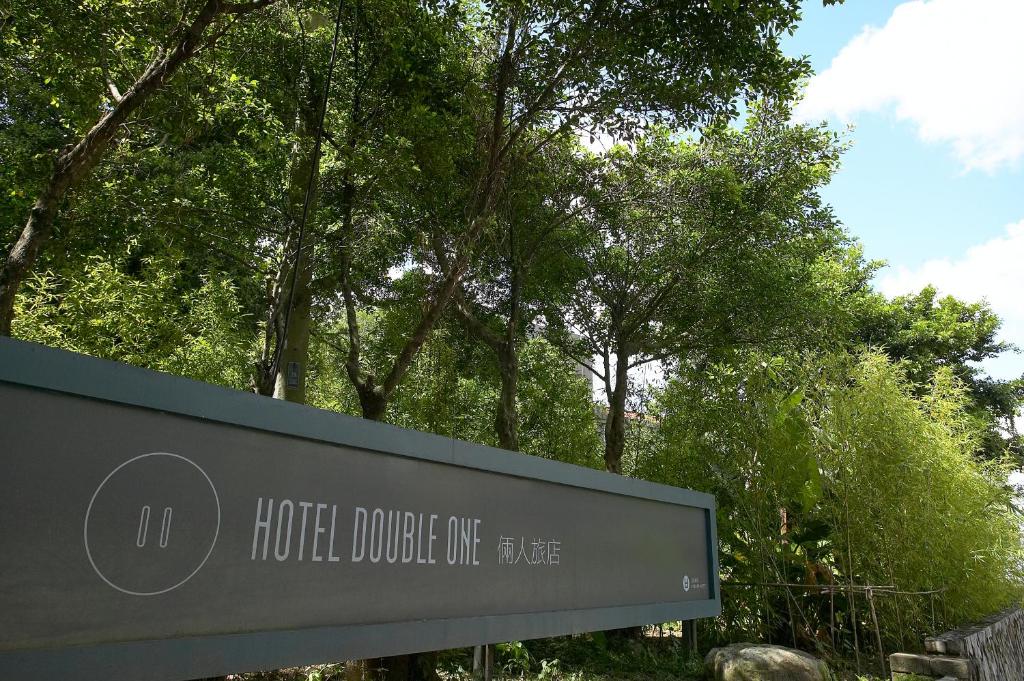 a sign for the houstonologic centre in front of trees at Hotel Double One in Taipei