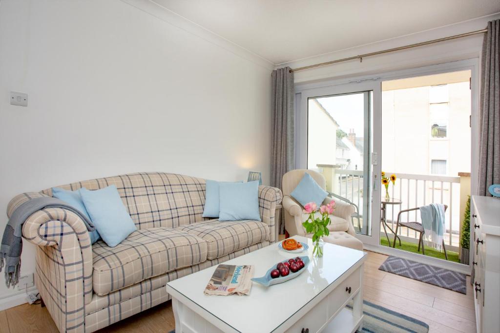 una sala de estar con un sofá y una mesa en The Sail Loft, en Sidmouth