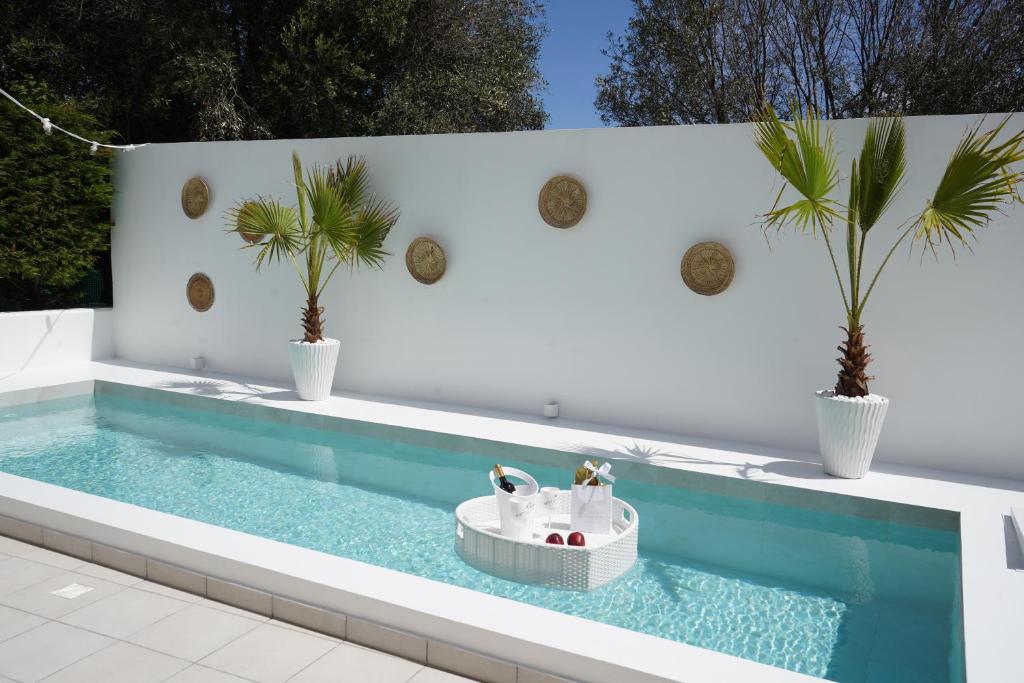a swimming pool with two palm trees and a tub at Villa Pastida - Private Pool and Jacuzzi in Pastida