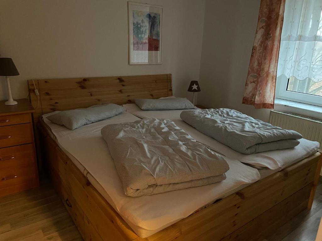 duże drewniane łóżko z 2 poduszkami w obiekcie Seeblick Wohnung 112 mit Ostseeblick w Koserowie