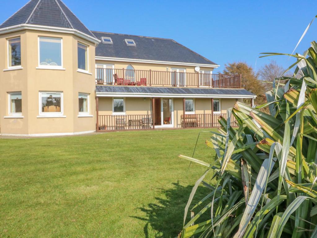 a large house with a lawn in front of it at Bluebell House and Gardens in Rossbrin