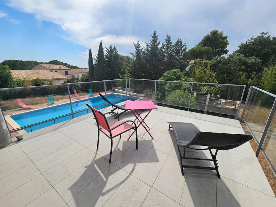 a patio with a table and chairs and a pool at L'Inattendue in Castelnau-le-Lez