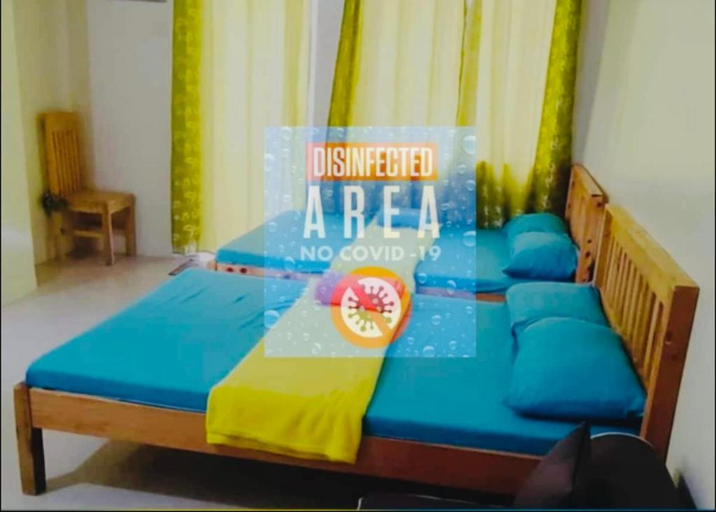Una cama en una habitación con un cartel. en Condo Premium Near NAIA T123, en Manila