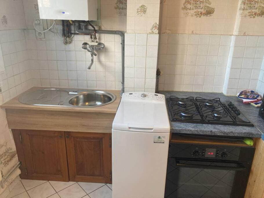 a small kitchen with a stove and a sink at Appartement T2 lumineux CHU Stade Gaston Gérard 2 nuits minimum in Dijon
