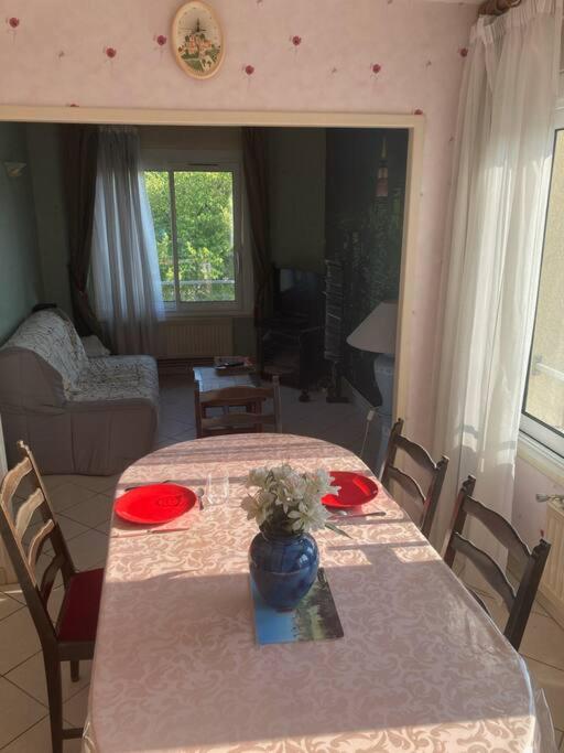 a dining room table with a vase on top of it at Appartement T2 lumineux CHU Stade Gaston Gérard 2 nuits minimum in Dijon