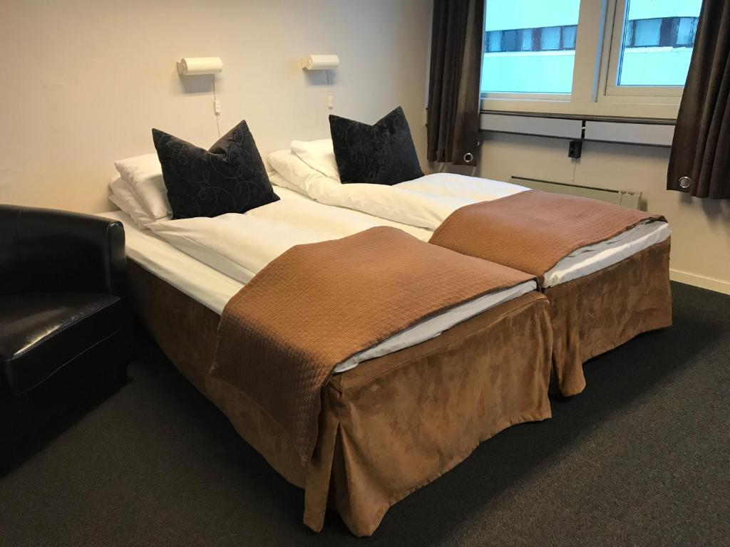two beds in a hotel room withskirts at Ågotnes Hotell & Motell in Ågotnes