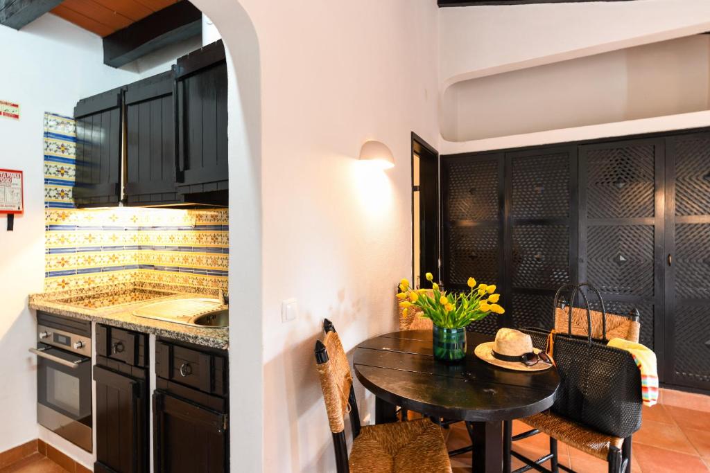a kitchen with a small table and a sink at Pedras D'el Rei in Tavira