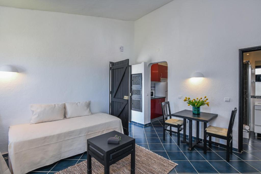 a room with a bed and a table and a kitchen at Pedras D'el Rei in Tavira