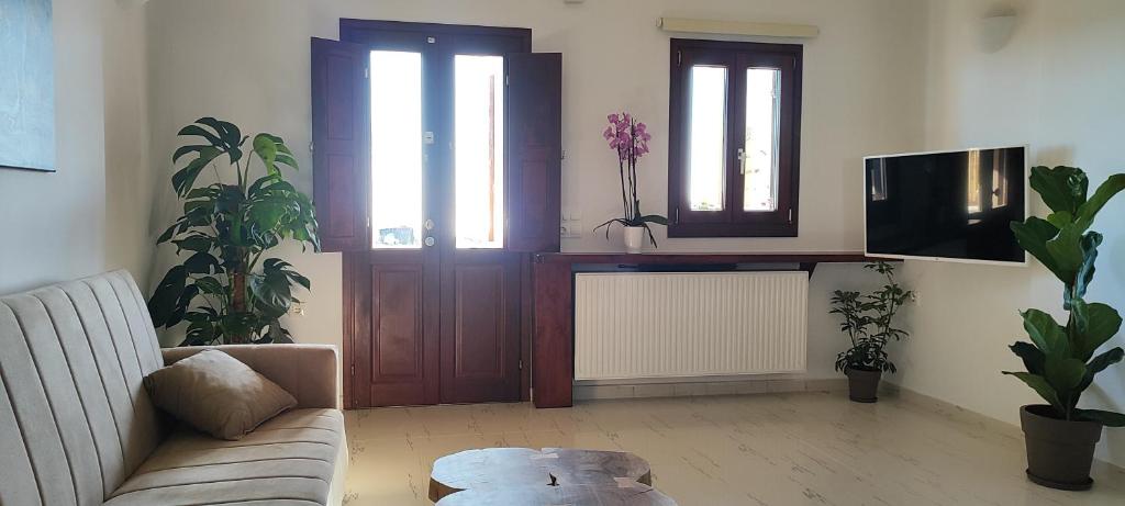 a living room with a couch and a tv at Kallistis Beach House in Monolithos