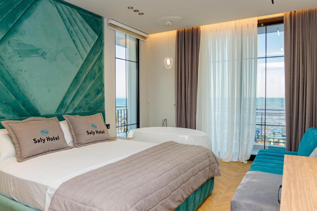 una camera d'albergo con letto, vasca e finestre di Hotel Saly a Durrës