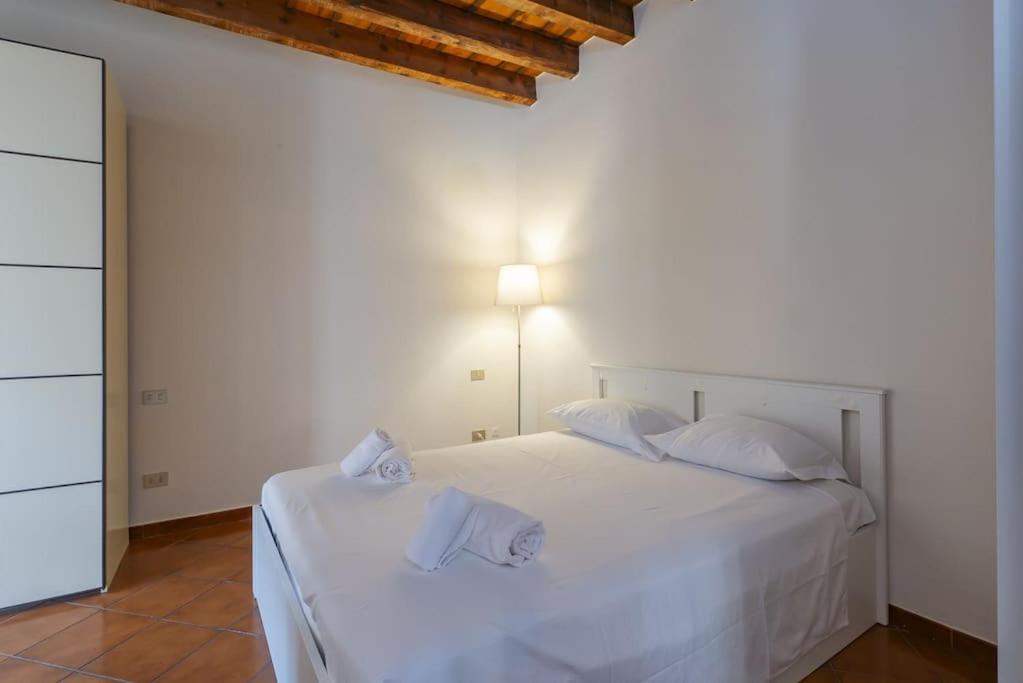 uma cama branca com almofadas brancas e um candeeiro em Youhosty - Ripa5 C em Milão