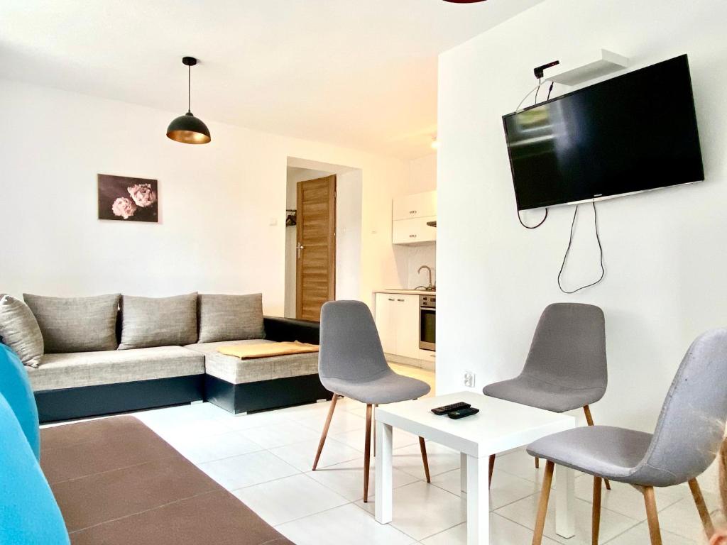 a living room with a couch and a table and chairs at Familly Apartament 2 in Międzyzdroje