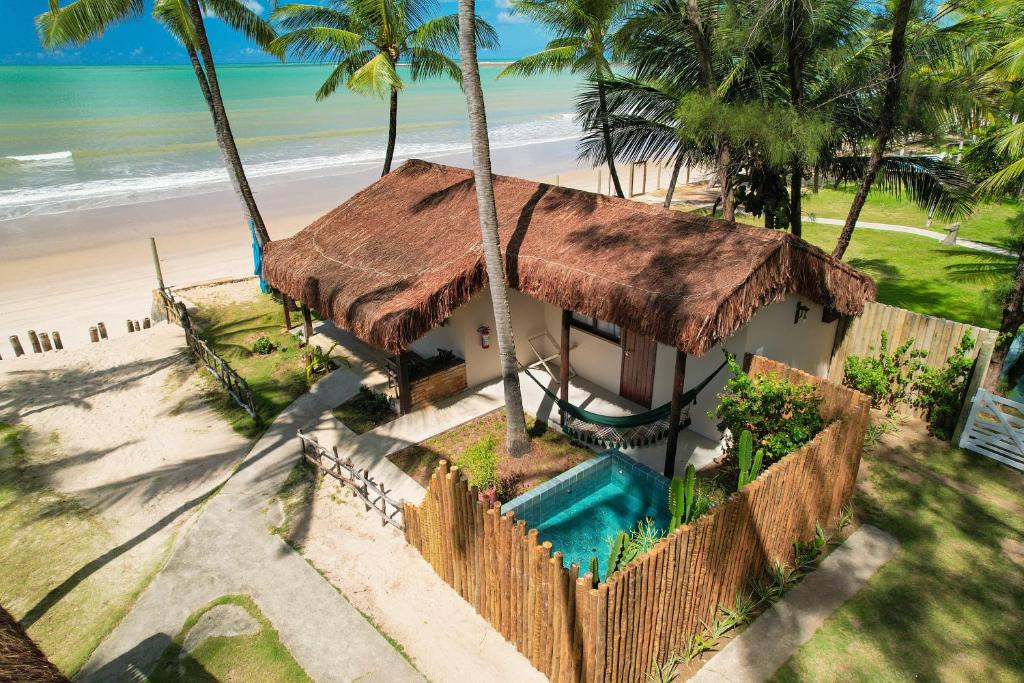 a house on the beach with a swimming pool at Pousada Xalés de Maracaípe in Porto De Galinhas