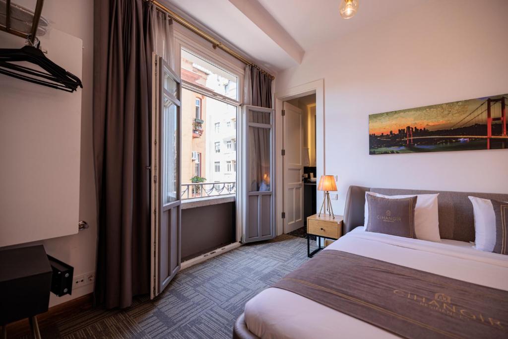 1 dormitorio con cama y ventana grande en Cihangir Residences, en Estambul