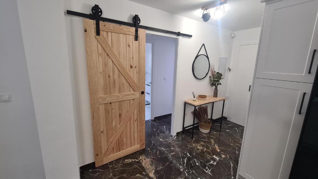 a room with a wooden door and a table at Albolafia junto Puente Romano in Córdoba