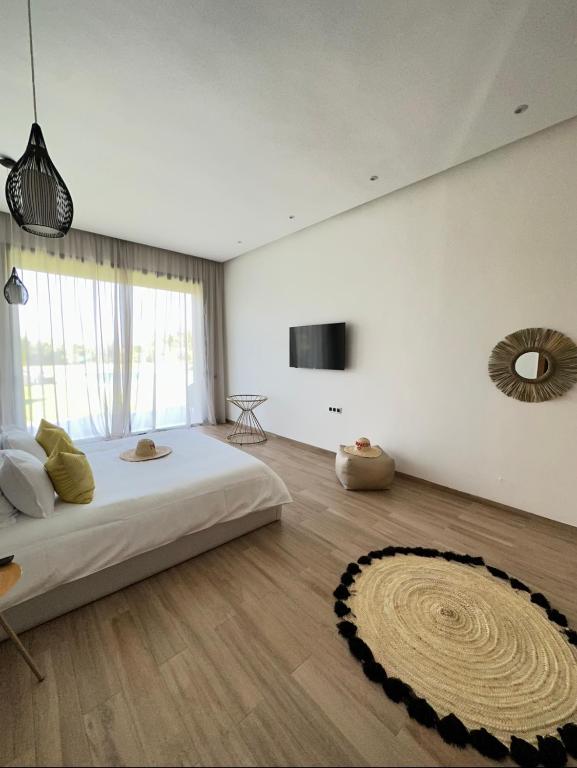 a bedroom with a large bed and a large window at Villa Jne Marrakech in Oulad Mazoug