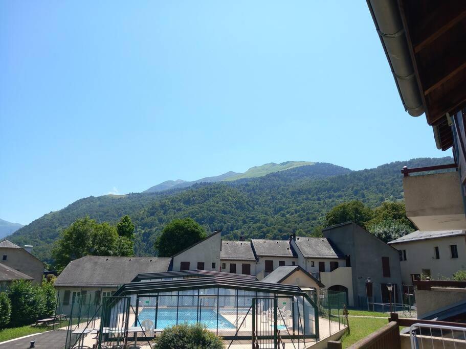 a building with a pool in the middle of a town at La Campana 104 in Bielle