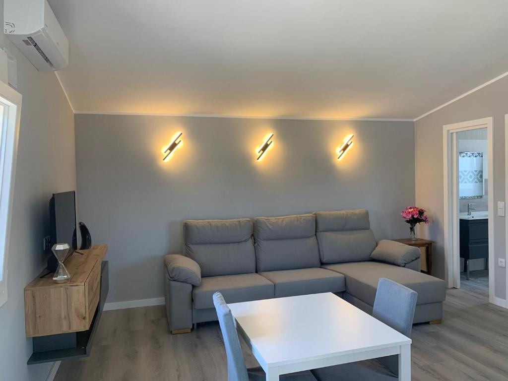 a living room with a couch and a table and lights at Casa ILEANA in Sanlúcar de Barrameda