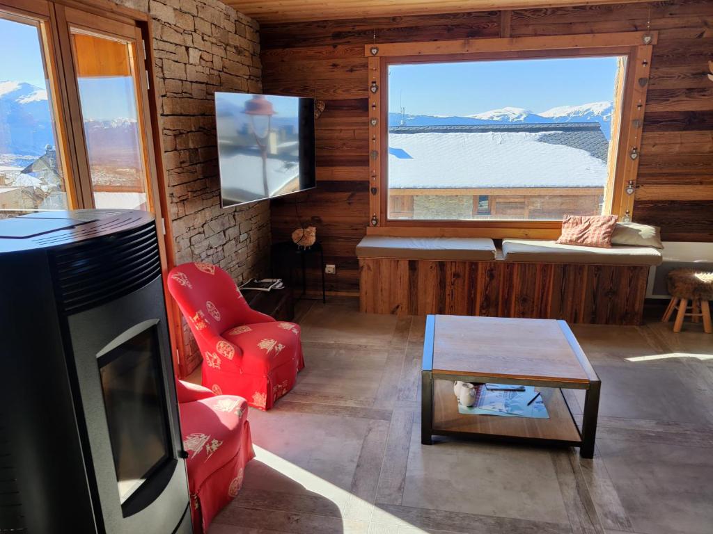 a living room with a tv and a large window at 3 Biches in Font-Romeu-Odeillo-Via