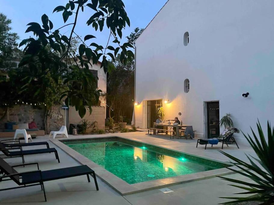 une piscine dans l'arrière-cour d'une maison dans l'établissement Grande Maison de Maitre contemporaine à 10 min de la mer et Piscine, à Salles-d'Aude