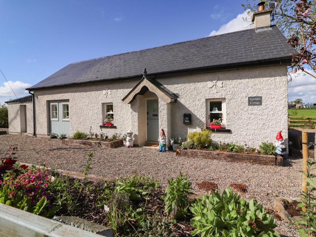 a white brick house with a garden in front of it at Lynchpin Cottage in Bruff