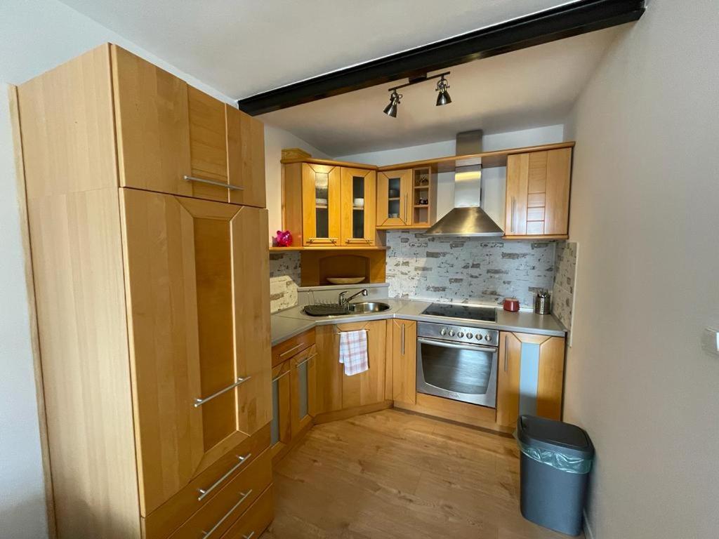 a kitchen with wooden cabinets and a stainless steel refrigerator at Apartments Netty in Dramalj