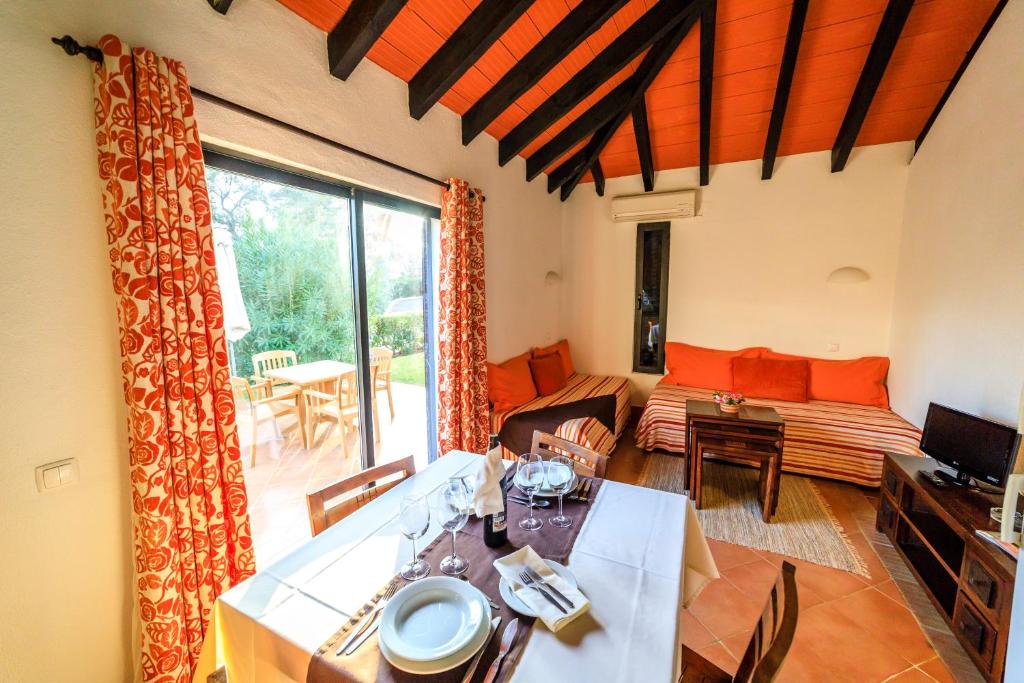a living room with a table and a couch at Pedras D'el Rei in Tavira