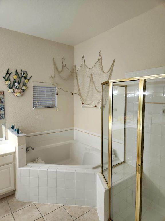 a bathroom with a tub and a glass shower stall at Bahama Bay 116 in Kissimmee