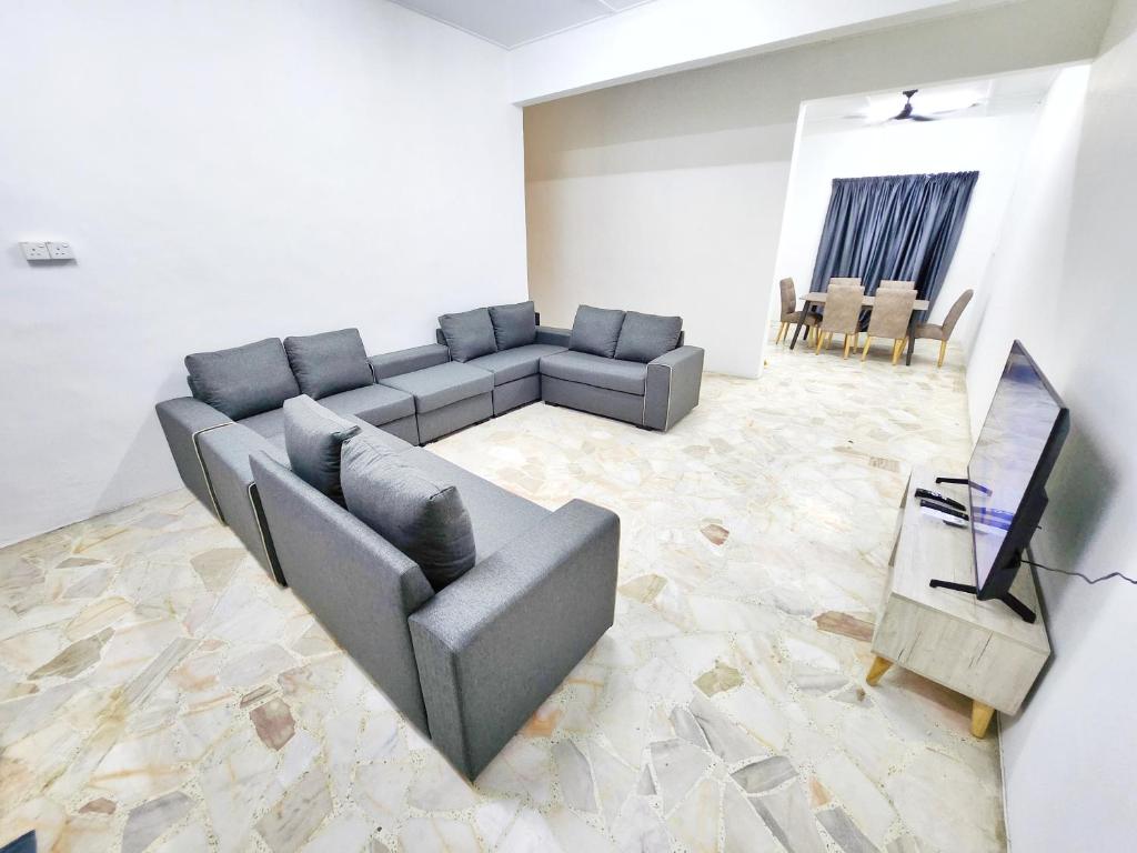 a living room with a couch and a television at Happy Vacation Homestay Mersing 2 in Mersing