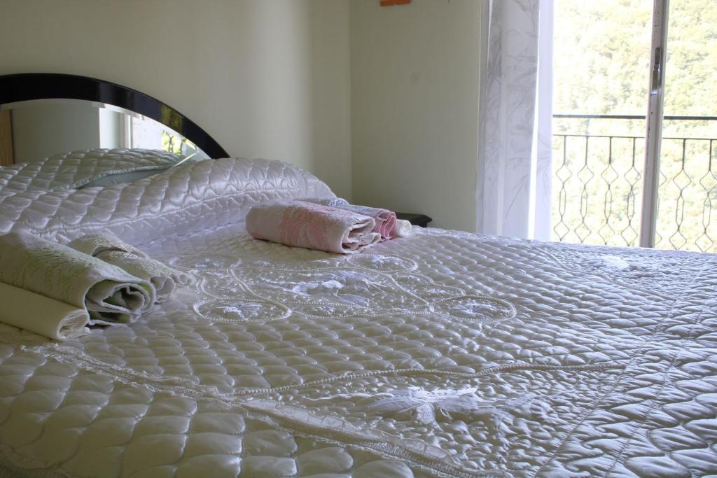 un letto bianco con lenzuola bianche e una finestra di Struttura L' Occhio sul Pollino a Mormanno