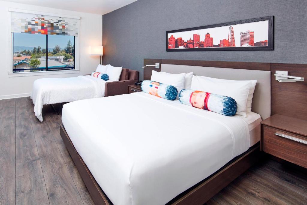 サンノゼにあるアロフト サン ノゼ クパチーノのベッド2台と窓が備わるホテルルームです。