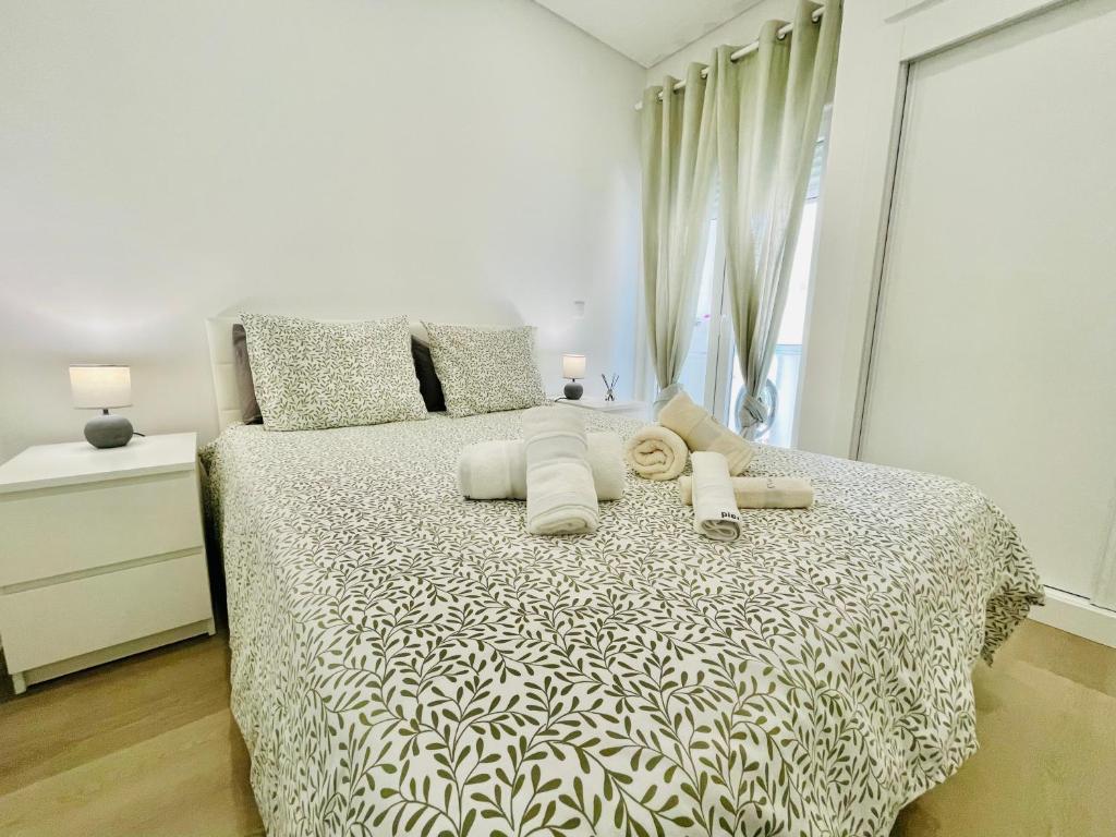a white bedroom with a bed with white sheets and pillows at Âncora - Beach 50m - Sea View Terrace in Armação de Pêra