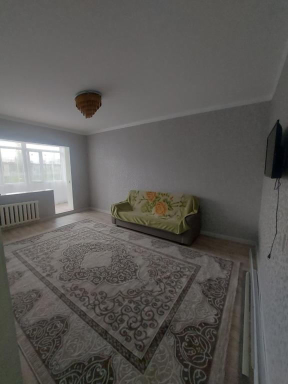 um quarto com um tapete no chão com uma cama em 2к.апартаменты.7 мкр. em Bishkek