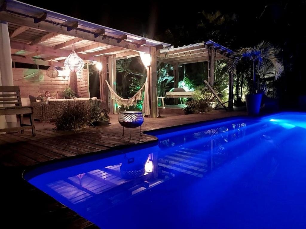 a swimming pool lit up at night at "Bungalow By Saeto" Hébergement privé chez l'habitant in Saint-Paul