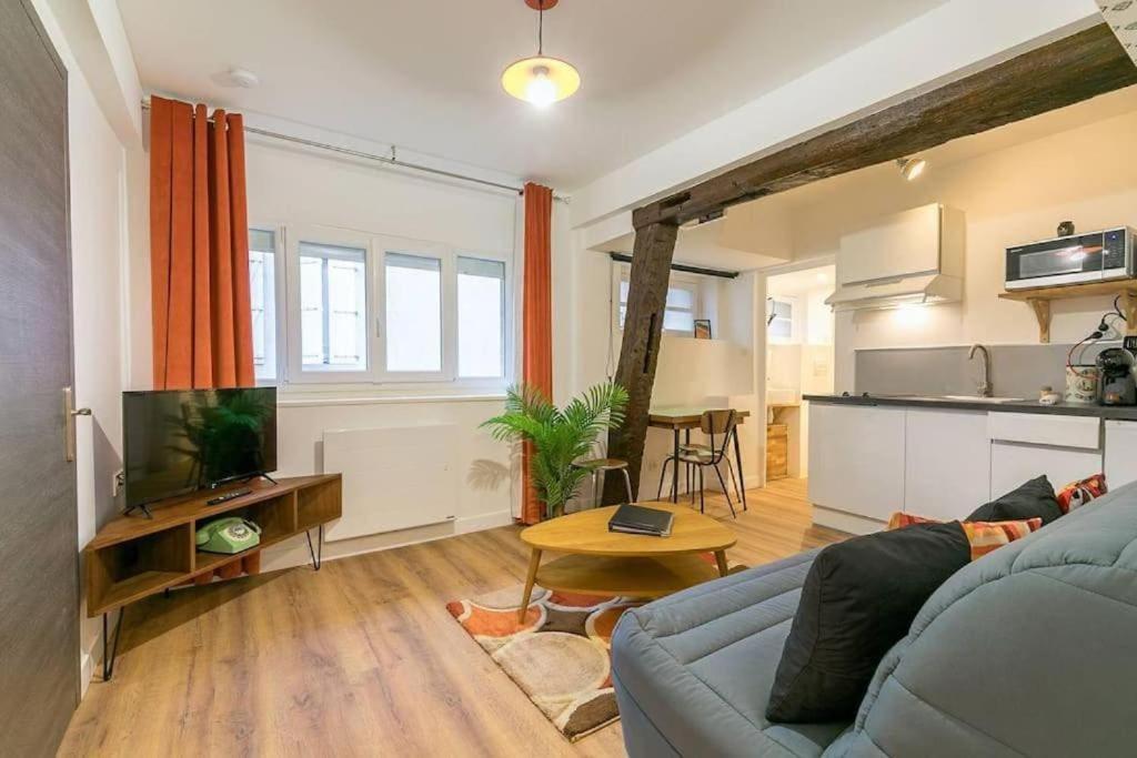 un salon avec un canapé bleu et une cuisine dans l'établissement Le Sweet 70's : au coeur du centre historique, à Dijon